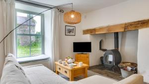 a living room with a bed and a tv at Ship Cottage in Bishopston