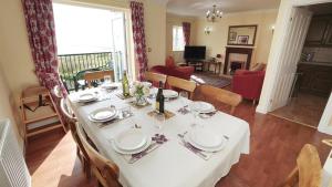 een eettafel met een wit tafelkleed erop bij Clover Cottage in Port-Eynon