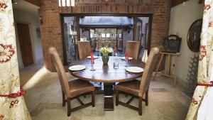 a dining room with a wooden table and chairs at Driftwood House in Parkmill