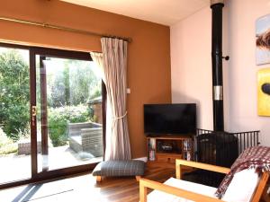 a living room with a television and a sliding glass door at 3 bed in Bude TRVVV in Poughill