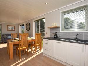 a kitchen and dining room with a table and chairs at 2 Bed in Conwy 60292 in Llangelynin