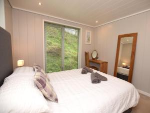 a bedroom with a white bed with a window at 2 Bed in Conwy 60292 in Llangelynin