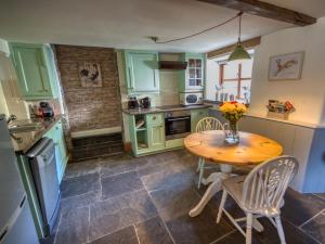 a kitchen with green cabinets and a wooden table at 1 bed in Wedmore 51341 in Chapel Allerton