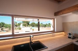 a kitchen with a sink and a large window at Ibiza Holliday Villa Harmony in Sant Jordi