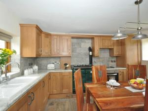 cocina con armarios de madera y mesa de madera en 3 bed in Coleford 52148 en Bream