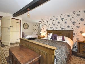 a bedroom with a large bed and floral wallpaper at 3 bed in Coleford 52148 in Bream