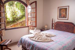 een slaapkamer met een bed en een groot raam bij Casa com lareira e Wi Fi em Campos do Jordao SP in Campos do Jordão