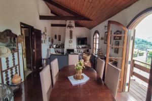 een eetkamer met een tafel en een keuken bij Casa com lareira e Wi Fi em Campos do Jordao SP in Campos do Jordão