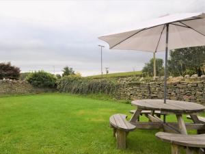 una mesa de picnic con una sombrilla en un campo en 3 bed in Coleford 52148 en Bream