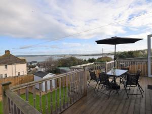 a table and chairs on a deck with an umbrella at 4 Bed in Appledore 55573 in Appledore