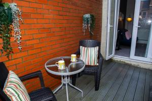 een tafel en twee stoelen op een veranda met twee kopjes bij North Bay Cabin 1 Bedroom Apartment Near The Beach in Scarborough