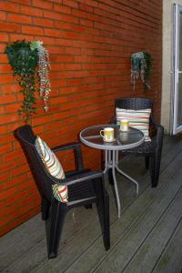 two chairs and a table with two cups on a patio at North Bay Cabin 1 Bedroom Apartment Near The Beach in Scarborough