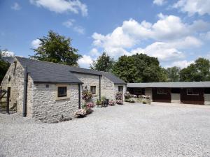 a stone barn with flowers in front of it at 1 Bed in Bradwell PK849 in Bradwell