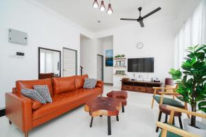 a living room with an orange couch and a table at Villapadu Kota in Kuala Terengganu