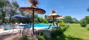 a patio with umbrellas and chairs next to a pool at Cabaña Alamos Altos in Belén de Escobar