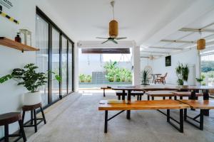 a dining room with tables and chairs and windows at Villapadu Kota in Kuala Terengganu