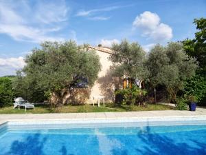una villa con piscina di fronte a una casa di location saisonnière a Pierrevert