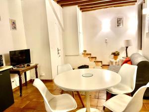 sala de estar con mesa blanca y sillas en La petite maison solognote, en La Ferté-Saint-Aubin