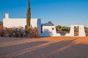 a building with a tree in the middle of a dirt road at Ibiza Holliday Villa Harmony in Sant Jordi