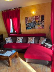 奇亚La Casa sulla collina "Baccu e Idda"的客厅里红色的沙发,配有红色的窗帘 更多37张照片