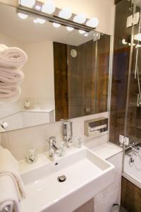 a white bathroom with a sink and a mirror at Hotel Gabriel in Le Mont Saint Michel