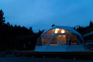 a blue iguana tent with lights in the night at 里山グランピングむすびペット棟 in Mizunami