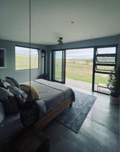 um quarto com uma cama e uma grande janela em The Villa at 40 Acres - Spacious Luxury Farmhouse on 16 hectares em Magaliesburg