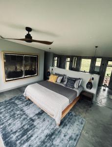 um quarto com uma cama grande e uma ventoinha de tecto em The Villa at 40 Acres - Spacious Luxury Farmhouse on 16 hectares em Magaliesburg