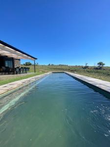uma piscina de água em frente a uma casa em The Villa at 40 Acres - Spacious Luxury Farmhouse on 16 hectares em Magaliesburg