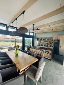 uma cozinha e sala de jantar com uma mesa de madeira e cadeiras em The Villa at 40 Acres - Spacious Luxury Farmhouse on 16 hectares em Magaliesburg