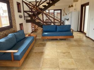 a living room with blue couches and a staircase at BEACH HOUSE Barra Grande - CASA INTEIRA - WHOLE HOUSE in Barra Grande