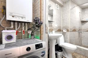 Un baño con lavadora y un inodoro. en Suzi Apartments, en Tiflis