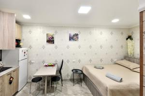 Una habitación con una cama y una mesa y una cocina. en Suzi Apartments, en Tiflis