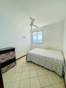 1 dormitorio con 1 cama y ventilador de techo en 2 Quartos Frente Mar em Itapuã, en Vila Velha