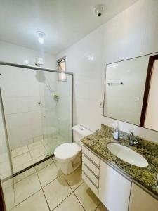 een badkamer met een toilet, een wastafel en een douche bij 2 Quartos Frente Mar em Itapuã in Vila Velha