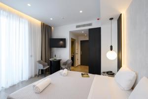 - une chambre avec un lit blanc et un salon dans l'établissement EcoHeaven Suites, à Amoudara