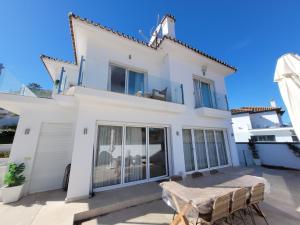 ein weißes Haus mit einem Tisch und Stühlen in der Unterkunft Private Luxurious Villa Walking Distance to Puerto Banus in Marbella + 39 Fotos