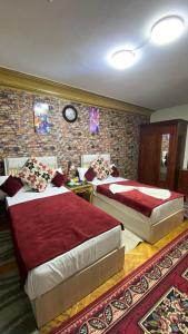 a bedroom with two beds and a brick wall at Nile Star Suites & Apartments in Cairo