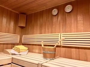 eine Sauna mit zwei Uhren an der Wand und einem Eimer in der Unterkunft Haus Wallis - Ski-In Ski-Out mit Frühstück am Arlberg in Warth am Arlberg