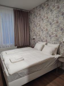 een slaapkamer met een groot bed met witte lakens bij Leeuwerik studio in Antwerpen