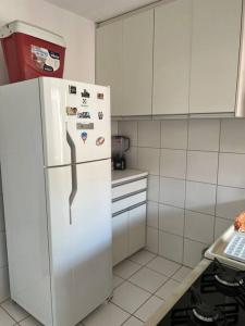 a kitchen with a white refrigerator with magnets on it at Casa de 2 quartos toda mobiliada in Brasilia