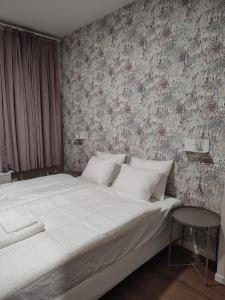een slaapkamer met een groot wit bed en een muur bij Leeuwerik studio in Antwerpen