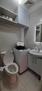 Amaze Staycation Makati في مانيلا: حمام ابيض مع مرحاض ومغسلة