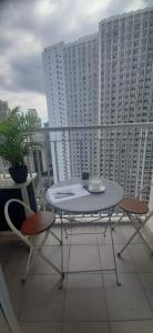 Amaze Staycation Makati في مانيلا: طاولة وكراسي على شرفة مع مباني