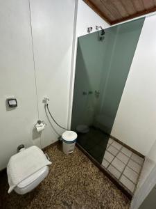 uma casa de banho com um WC e uma cabina de duche em vidro. em Hotel Sol da Praia em Vitória