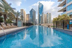 een zwembad met een skyline van de stad op de achtergrond bij Premium stay at the Marina Quays West in Dubai