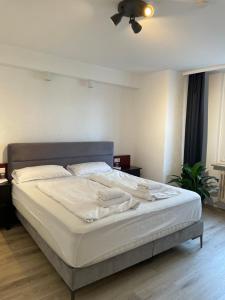 ein großes Bett in einem Schlafzimmer mit Deckenventilator in der Unterkunft TRUST Hotel & Apartment in Stuttgart