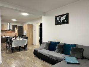 ein Wohnzimmer mit einem Sofa und einem Tisch in der Unterkunft Family Duplex 3BR au Coeur de Talange in Talange
