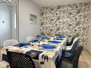 een tafel met blauwe servetten en stoelen in een kamer bij Maison Saint-Gilles-Croix-de-Vie, 4 pièces, 6 personnes - FR-1-224-750 in Saint-Gilles-Croix-de-Vie