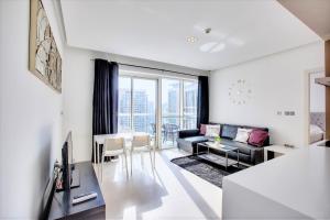 uma sala de estar com um sofá e uma mesa em New Stylish 1 BD in West Avenue Marina em Dubai